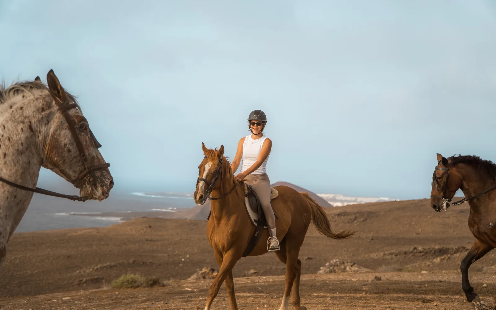 A relaxed first-time rider smiling on her horse