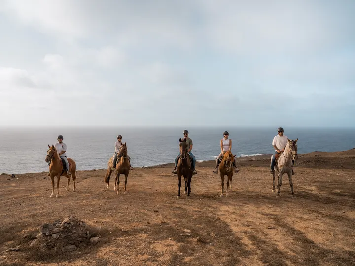 A group on horseback above the Lanzarote coast